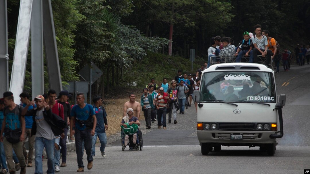 Honduran migrant Omar Orella pushes fellow migrant Nery Maldonado Tejeda in a wheelchair, as they travel with hundreds of other Honduran migrants making their way to the U.S., near Chiquimula, Guatemala, Oct. 16, 2018. Maldonado said he lost his legs in 2015 while riding "The Beast," a northbound cargo train that crosses Mexico, and that this was his second attempt to reach the U.S.
