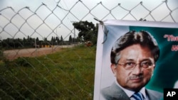 Sebuah poster mantan Presiden Pakistan Pervez Musharraf terlihat terpasang di pintu gerbang rumahnya yang dijaga ketat di Islamabad, Pakistan, 6 November 2013 (Foto: dok). Ancamam bom membuat sidang pertama terhadap Musharraf ditangguhkan pelaksanaannya, Selasa (24/12). 