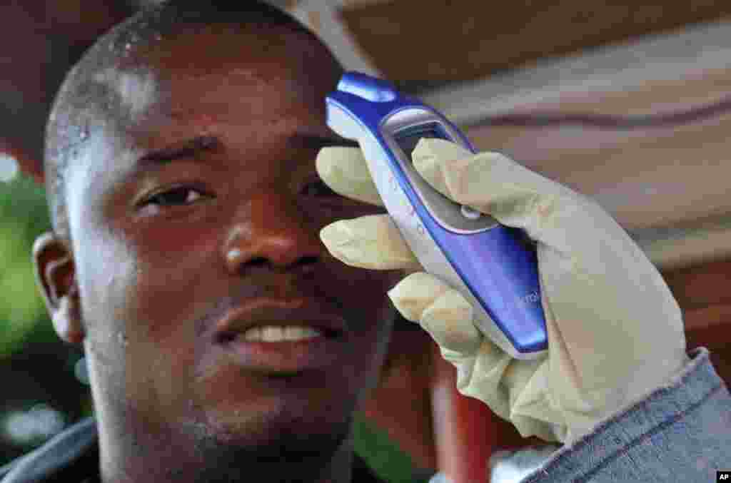 A man&#39;s temperature is measured before he is allowed into a business center, as fear of the deadly Ebola virus spreads through the city of Monrovia, Liberia, Aug. 9, 2014.