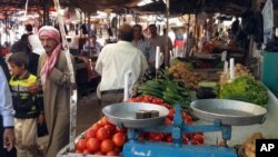 FILE - People shop at a market in the northern city of Mosul, Iraq. 