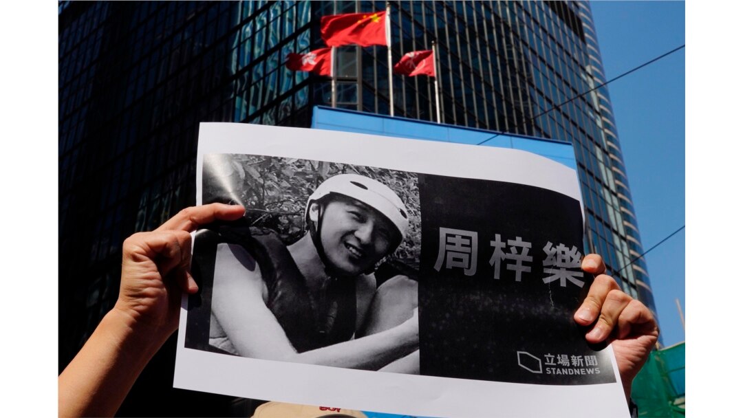 A protester holds a photo of Chow Tsz-Lok during a memorial flash mob to remember him, Nov. 8, 2019. Chow, a Hong Kong university student, fell off a parking garage after police fired tear gas during clashes with protesters and died Friday.