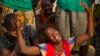 A woman reacts near the dead body of her sister who was killed during one of the latest incidents of sectarian violence in the 5th Arrondissement of the capital Bangui February 9, 2014. REUTERS/Siegfried Modola 