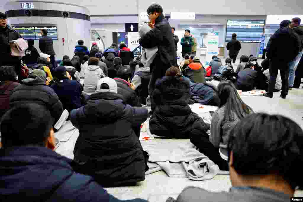 Familiares de los pasajeros del avión que se estrelló tras salirse de la pista, reunidos en el Aeropuerto Internacional de Muan, el 29 de diciembre de 2024.