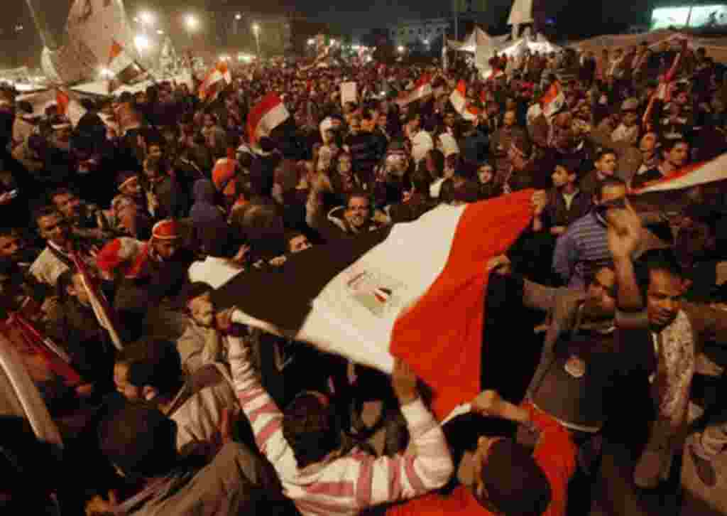 Egyptian citizens wave their country's flag as they celebrate after President Hosni Mubarak resigned and handed power to the military at Tahrir square, in Cairo, Egypt, Friday, Feb. 11, 2011. Egypt exploded with joy, tears, and relief after pro-democracy