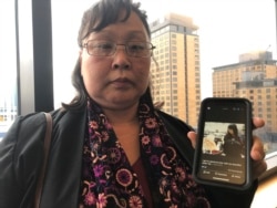Rena Sapp, outside a courtroom Monday, Oct. 21, 2019, in Anchorage, Alaska, shows a photo of her sister, Veronica Abouchuk. Sapp attended the arraignment of Brian Steven Smith, who is accused of killing Abouchuk.