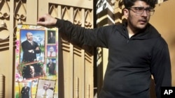 Osama Rizi, son of a journalist Rizwan-ur-Rehman Razi, displays a calendar with the pictures of his father outside his residence in Lahore, Pakistan, Feb. 9, 2019. 