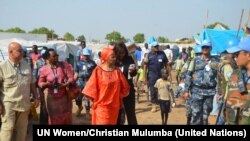 The executive director of UN Women, Phumzile Mlambo-Ngcuka (third from left) is briefed as she tours a U.N. base in Juba where thousands of people have sought shelter from weeks of unrest in South Sudan.