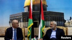 Senior Hamas leader Ismail Haniyeh (R) speaks with Palestinian Prime Minister Rami Hamdallah at Haniyeh's house in Gaza City, Oct. 9, 2014. 