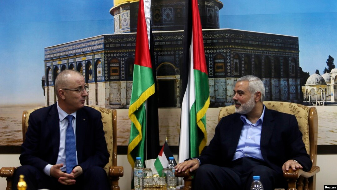 Pemimpin Hamas Ismail Haniyeh (kanan) berbicara dengan PM Palestina Rami Hamdallah di Gaza (9/10).