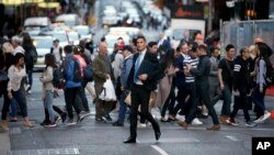 FILE - Pedestrians cross a road in Sydney, Australia, Sept. 6, 2017. Australia's population has reached 25 million for the first time, according to official estimates.