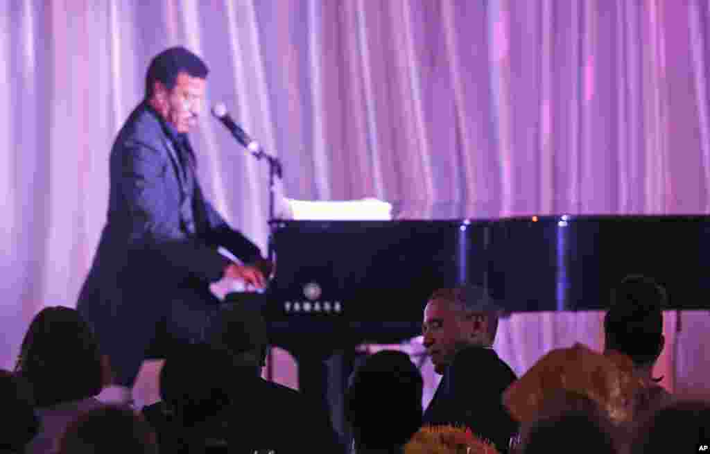 Singer Lionel Richie performs at a dinner hosted by President Barack Obama, seated second right, with first lady Michelle Obama for the U.S. - Africa Leaders Summit, on the South Lawn of the White House, Aug. 5, 2014.