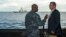 U.S. Secretary of Defense Ash Carter (R) speaks with U.S. Navy Cmdr. Robert C. Francis Jr., as Carter and Malaysian Defense Minister Hishammuddin Hussein (not pictured) visited the USS Theodore Roosevelt aircraft carrier in the South China Sea, in this handout image, Nov. 5, 2015.