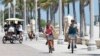 FILE -- Riders along the Hollywood Beach Broadwalk, in Florida, which was the most popular destination for home buyers who moved out of state in 2018. 