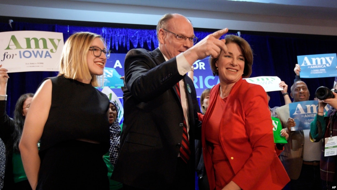 Democratic presidential candidate Sen. Amy Klobuchar, D-Minn., stands with her husband, John Bessler, and daughter Abigail Klobuchar Bessler, left, after speaking to supporters at her caucus night campaign rally in Des Moines, Iowa.