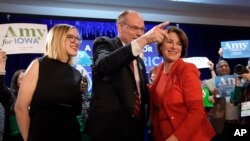 Democratic presidential candidate Sen. Amy Klobuchar, D-Minn., stands with her husband, John Bessler, and daughter Abigail Klobuchar Bessler, left, after speaking to supporters at her caucus night campaign rally in Des Moines, Iowa.