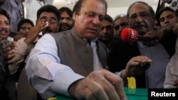 Nawaz Sharif, pemimpin partai politik Liga Muslim Pakistan- Nawaz (PML-N) memasukkan surat suaranya di kotak suara di salah satu TPS di Lahore (11/5).