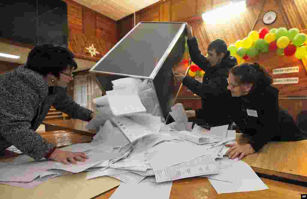 Electoral commission staff empty a ballot box after voting closed at a polling station in the village of Ust-Mana some 30 km (19 miles) from Russia's Siberian city of Krasnoyarsk, December 4, 2011. (Reuters)