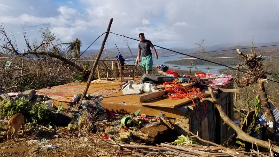 Seorang pria memeriksa rumahnya yang rusak akibat Topan Rai di Kepulauan Dinagat, Filipina selatan pada Minggu 19 Desember 2021. (Foto: via AP)