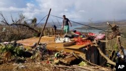 Seorang pria memeriksa rumahnya yang rusak akibat Topan Rai di Kepulauan Dinagat, Filipina selatan pada Minggu 19 Desember 2021. (Foto: via AP)