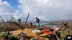 Seorang pria di memeriksa rumahnya yang porak poranda di Kepulauan Dinagat pada 19 Desember 2021, akibat Topan Rai yang melanda Filipina pekan lalu. (Foto: Office of the Vice President via AP)