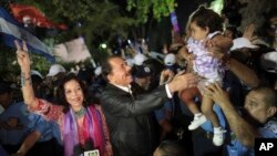 FILE.- In this Nov. 8, 2011 file photo Nicaragua's President Daniel Ortega, center, accompanied by his wife Rosario Murillo, left, greets supporters after delivering an address to the nation in Revolution Square in Managua, Nicaragua. First lady Rosario M