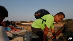 Un migrante centroamericano sube al techo de un tren de carga, de camino a la frontera de EE.UU. con México, en Ixtepec, estado de Oaxaca, México, el 23 de abril de 2019. El tren es conocido como "La Bestia".