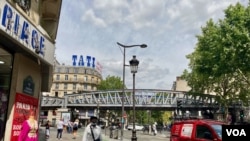 Tati's famous blue-and-pink logo soars over the Barbes Rouchechouart metro station in Paris. (Lisa Bryant/VOA)