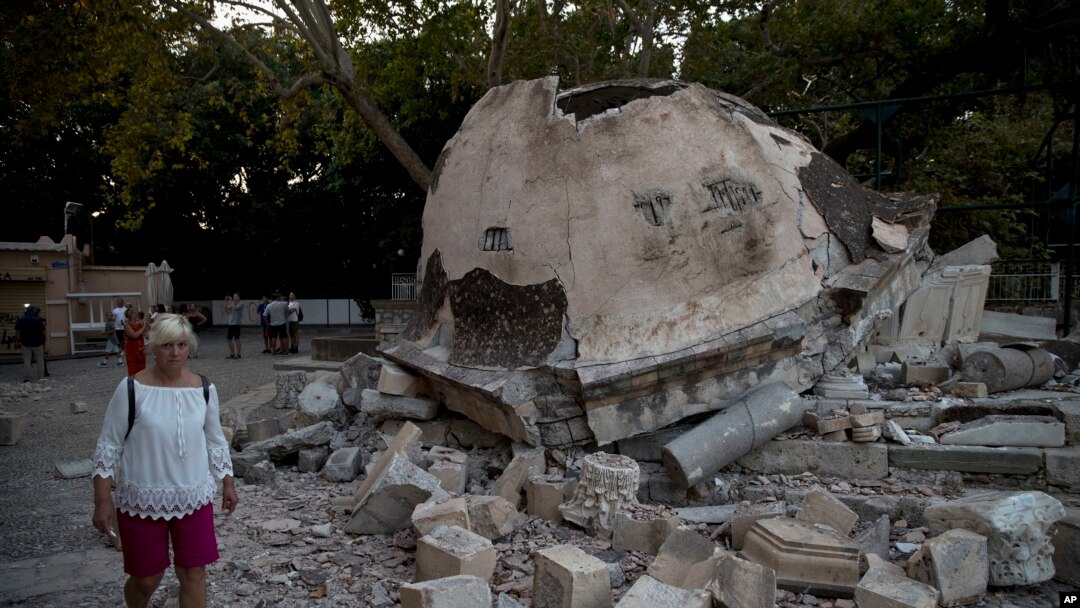 Seorang wisatawan berjalan melintasi struktur bangunan masjid yang hancur seteleh dilanda gempa bumi di Pulau Kos, Yunani, 22 Juli 2017 (foto: AP Photo/Petros Giannakouris) 