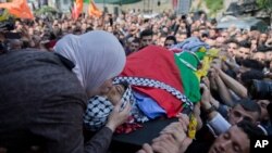 Wafa Manasra, mother of Palestinian Ahmad Jamal Manasra, 26, kisses him goodbye during his funeral in the West Bank village of Wad Fokin, near Bethlehem, Thursday, March 21, 2019. The governor of the West Bank city of Bethlehem said Thursday that Israeli…