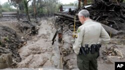 Senior deputy Jeff Farmer with the Santa Barbara County Sheriff office checks the Montecito Creek to make sure it is flowing correctly, March 22, 2018.