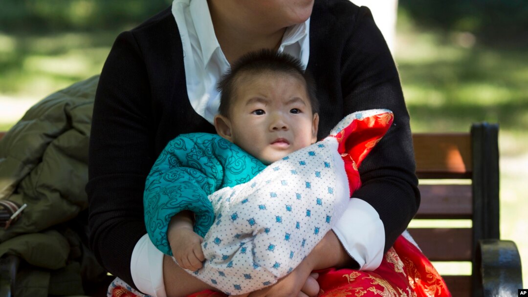 Seorang ibu mengasuh bayinya di sebuah taman di Beijing, China (30/10). China mengatakan kebijakan satu anak di negara itu masih tetap berlaku untuk saat ini.