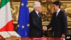 Le président italien Sergio Mattarella serre la main à Giuseppe Conte lors de la cérémonie d'instauration du nouveau gouvernement à Rome, le 1 juin 2018.