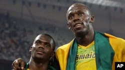 FILE - In this Friday, Aug. 22, 2008 file photo members of Jamaica's gold medal winning relay team Nesta Carter and Usain Bolt, right, celebrate after the men's 4x100-meter relay final during the athletics competitions in the National Stadium at the Beijing 2008 Olympics in Beijing. Bolt has been stripped of one of his nine Olympic gold medals, Wednesday Jan. 25, 2017, in a doping case involving teammate Nesta Carter.