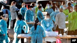 资料照片：亚利桑那州凤凰城的医护人员准备为驾车人进行新冠病毒检测（2020年6月27日）