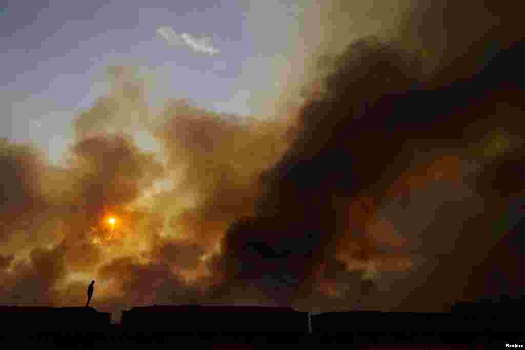 A man looks at smoke rising from wildfires in Brasilia National Park, in Brasilia, Brazil, Sept. 16, 2024. 