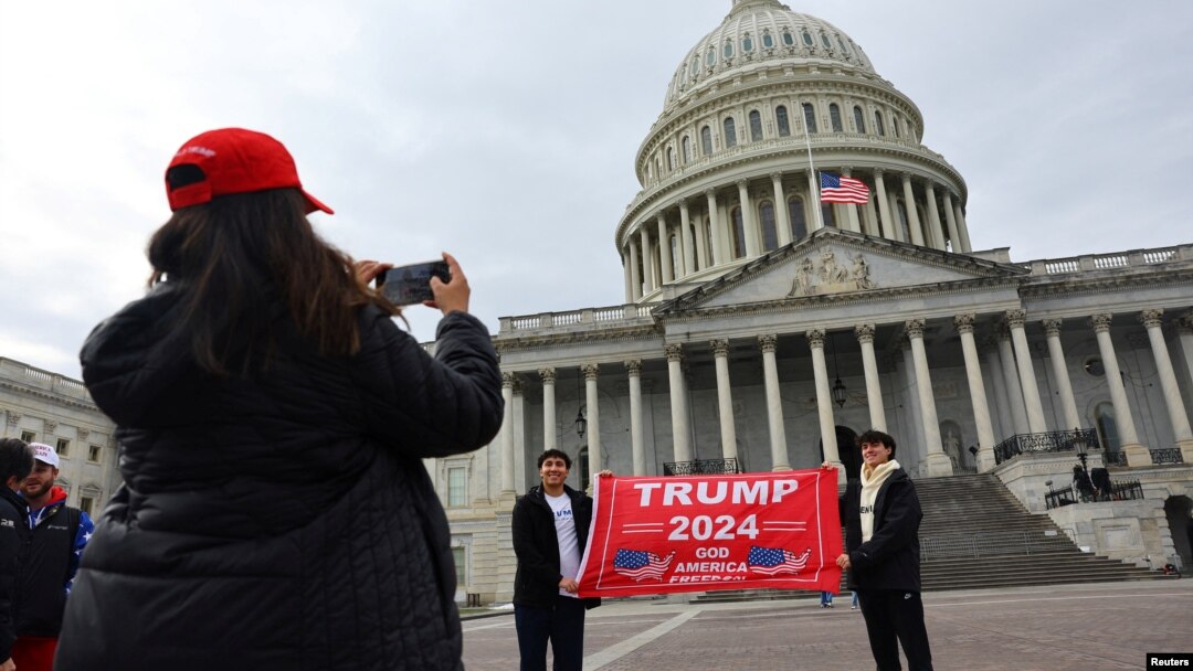 Поддржувачи на Трамп се фотографираат пред зградата на американскиот конгрес во Вашингтон на 18 јануари, 2025