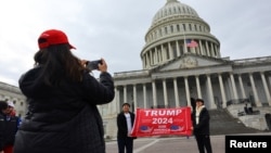 Поддржувачи на Трамп се фотографираат пред зградата на американскиот конгрес во Вашингтон на 18 јануари, 2025