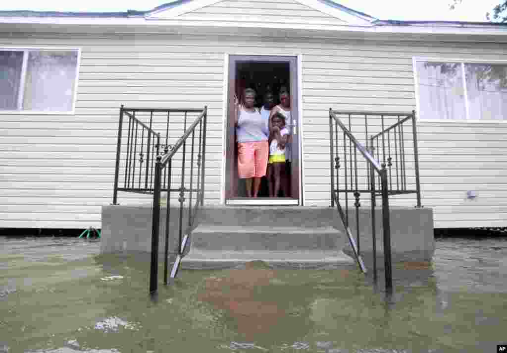 (from L to R) Lessie Lewis, Devin Lewis, Kodi Lewis and Cindy Lewis stand on the front porch as flood waters surround their home on St. Roch ave. as Hurricane Isaac makes land fall in New Orleans, Louisiana August 29, 2012.