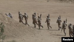 FILE - Pakistan Rangers walk with their weapons during a counter-terrorism training demonstration on the outskirts of Karachi, Pakistan, Feb. 24, 2015. Pakistan’s military announced Saturday it has taken control of an ongoing police-led security operation to evict gangsters from their island hideout in the country’s most populous province of Punjab.