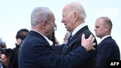 Israel Prime Minister Benjamin Netanyahu (L) greets US President Joe Biden upon his arrival at Tel Aviv's Ben Gurion airport on October 18, 2023, amid the ongoing battles between Israel and the Palestinian group Hamas. (Photo by Brendan SMIALOWSKI / AFP)