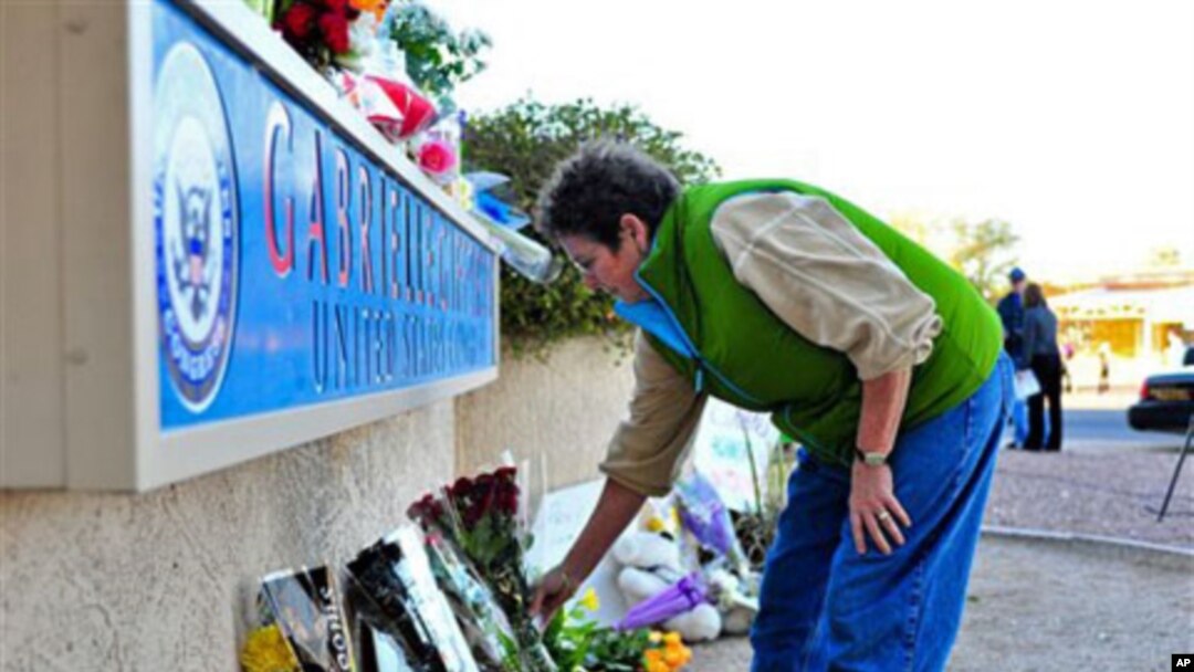 A woman leaves flowers outside the office of Congresswoman Gabrielle Giffords in Tucson, Arizona, 08 Jan 2011