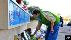 A woman leaves flowers outside the office of Congresswoman Gabrielle Giffords in Tucson, Arizona, 08 Jan 2011