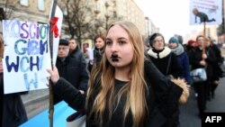 Women attend a rally held on International Women's Day in Warsaw on March 8, 2017. 