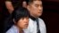 FILE - Philippine national Mary Jane Veloso, left, who is on death row for drug offences, accompanied by an unidentified interpreter, attends her judicial review hearing at Sleman District Court in Yogyakarta, Indonesia, March 4, 2015.