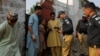 FILE - Pakistani police officers, along with workers from the National Database and Registration Authority, check the identity cards of Afghan citizens during a search and verification drive for undocumented Afghan nationals, near Karachi, Pakistan, Nov. 21, 2023.