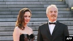 Yönetmen Orhan Oğuz ve oyuncu Nilüfer Açıkalın Şangay Uluslararası Film Festivali öncesinde düzenlenen kırmızı halı töreninde fotoğrafçılara poz verirken (AP Photo/Eugene Hoshiko)