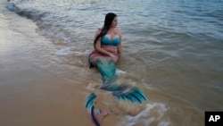 FILE - Lauren Metzler prepares for a swim at Manly Cove Beach in Sydney, Australia, Thursday, May 26, 2022. Mermaid does not have to worry about sink or swim. (AP Photo/Mark Baker)