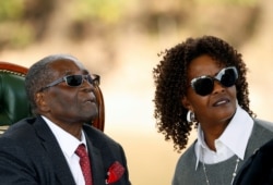 FILE - Zimbabwe's former president Robert Mugabe and his wife Grace look on after addressing a news conference at his private residence in Harare, Zimbabwe, July 29, 2018.