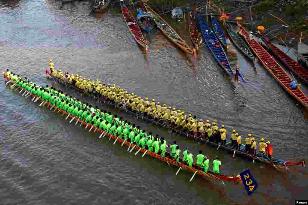 Participants row their long boats to warm up during the annual water festival on the Tonle Sap river in Phnom Penh, Cambodia.