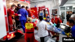 Tim medis tengah menolong seorang korban kebakaran sebuah club malam di Bucharest, Romania (31/10). Sedikitnya 27 orang tewas dan 184 lainnya terluka akibat kebakaran saat berlangsungnya konser musik rock "Goodbye to Gravity" di klub Colective di kota itu.